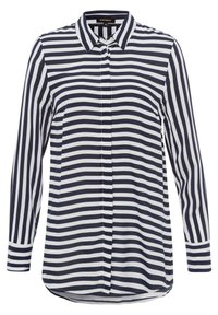 Blusa a righe blu navy e bianche con maniche lunghe, chiusura con bottoni frontale e colletto. Tessuto morbido con una vestibilità leggermente ampia e fondo arrotondato.