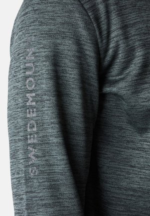 Dunkelgraues Strickshirt mit langen Ärmeln und strukturiertem Muster, mit "SWEDEMOUNT" vertikal auf dem linken Ärmel in hellgrau bedruckt.