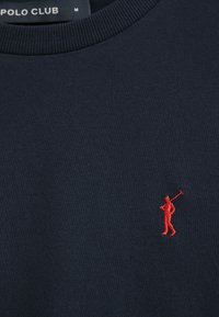 Marineblaues Sweatshirt mit rundem Ausschnitt, gefertigt aus weichem Material. Verfügt über eine kleine rote gestickte Figur auf der linken Seite.