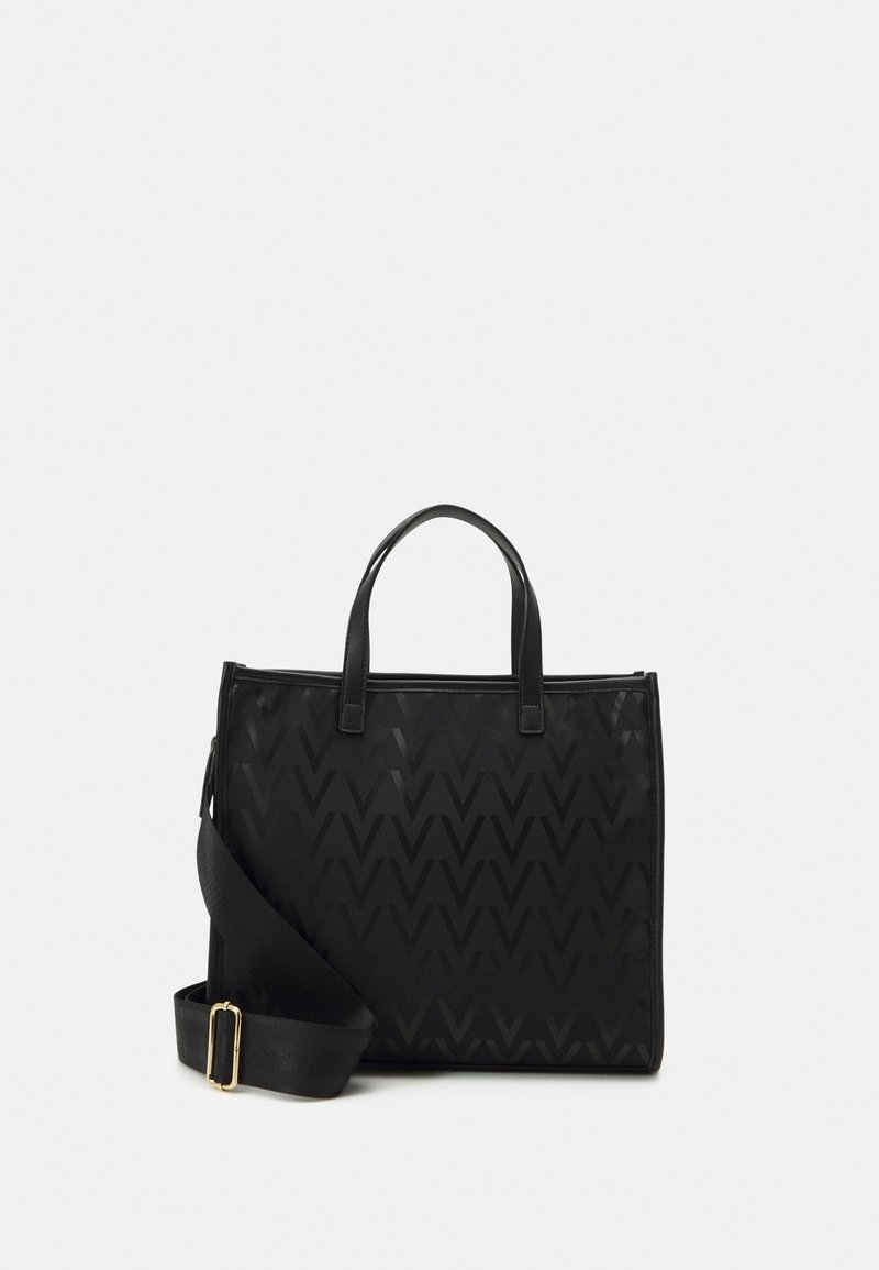 Svart tote-väska med ett strukturerat, zigzag-mönster. Har dubbla handtag upptill och en justerbar axelrem. Dragkedjestängning och slät yta.