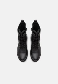 Czarne skórzane botki za kostkę o teksturowanym wykończeniu, z frontowym sznurowaniem, bocznym zamkiem błyskawicznym oraz okrągłym czubkiem. Gładka powierzchnia i solidna podeszwa.