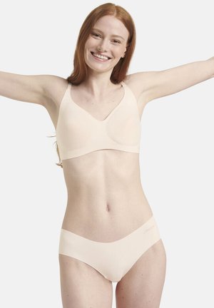 Beige saumaton rintaliivit ja vastaavat bikinit. Pehmeä kangas, jolla on sileä pinta. Rintaliiveissä on leveät olkaimet; bikineissä on matala vyötärödesign.