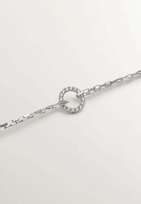 Pulsera de plata con un diseño de cadena vinculada y un centro circular adornado con pequeñas gemas, creando un patrón texturizado.