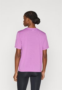 Αθλητικό μπλουζάκι με κοντά μανίκια σε ανοιχτό μωβ χρώμα, ελαφρύ ύφασμα, στρογγυλή λαιμόκοψη, διακριτικό υφασμάτινο μοτίβο, με μικρό λογότυπο στο πίσω μέρος.