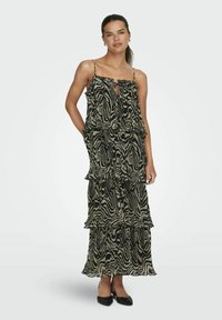 Robe maxi à imprimé zèbre noir et crème, dotée de fines bretelles, d'un lien à l'avant et de volants superposés le long de la jupe. Fabriquée en tissu léger.