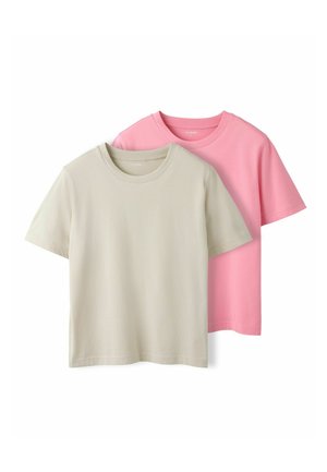 Twee effen katoenen T-shirts, één beige die voor een roze is gelegd, tentoongesteld tegen een witte achtergrond.