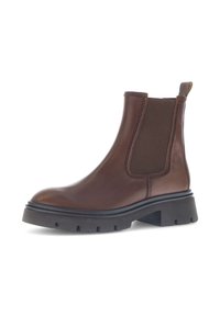 Brown leather Chelsea boot with elastic side panels, round toe, and a chunky black rubber sole featuring deep tread for traction.