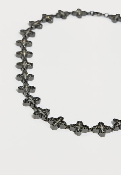 Fekete nyaklánc, amely összekapcsolt kereszt alakú elemekből áll, texturált felületekkel és fényes díszítésekkel, finom és egyenletes kialakítást alkotva.