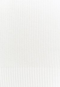 Maglione bianco lavorato a maglia con orlo testurizzato e a coste e un pattern uniforme su tutto il corpo per un aspetto visivamente omogeneo.
