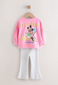 Roosa pusa, millel on multikategelaste graafiline kujundus ja tekst "THE CREW"; kombineeritud hallide, lehvikukujuliste retuusidega, mõlemad pehmest kangast.