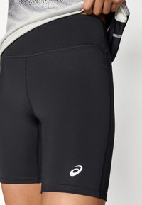 Μαύρο αθλητικό σορτς από λεία, ελαστ ική ύλη. Διαθέτει εφαρμοστή σχεδίαση με λευκό λογότυπο στο τελείωμα και επίπεδες ραφές.