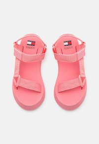 Rosa sandaler med tjocka remmar och en mjuk sula. Har en texturerad remdesign och logotyp på fotbädden. Lätta och öppna framtill.