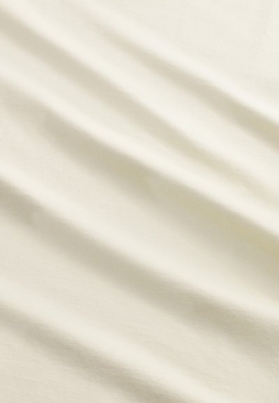 Cremefarvet stof, der viser en subtil tekstur med bløde, flydende folder. Overfladen er glat, hvilket fremhæver dens lette kvalitet.