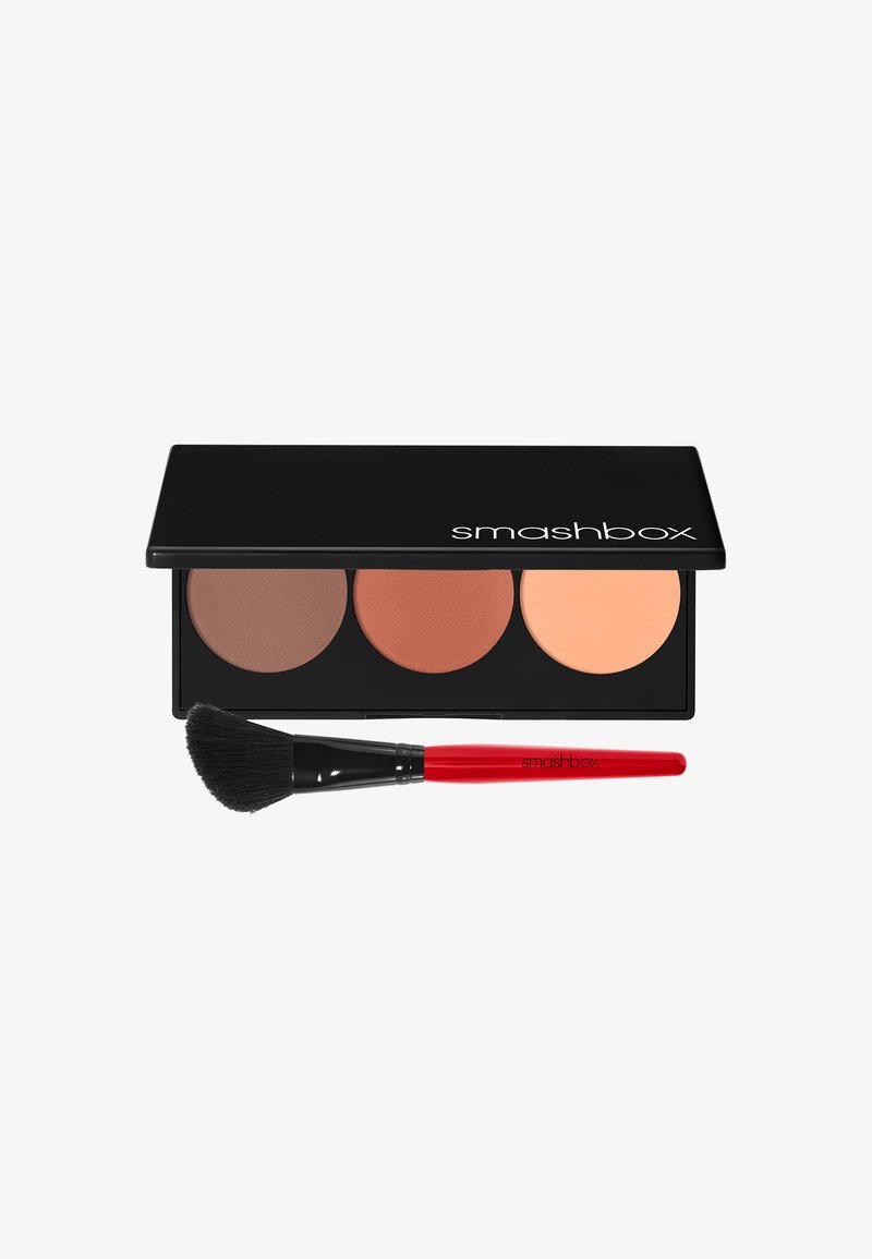 Palette de contour Smashbox avec trois poudres pressées dans des teintes brunes, orange et pêche ; inclut un pinceau noir avec un manche rouge.