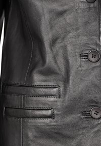 Zwarte leren jas met een gladde textuur, knoopsluiting en zijzak met geborduurde details.