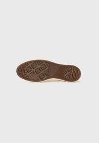 Rubber shoe sole in brown with a textured diamond pattern and ridged sections, featuring a smooth edge.