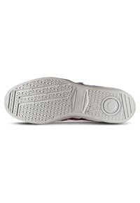 Suela de zapato de goma con una superficie texturizada, que presenta un patrón ondulado y un disco circular en la entresuela. Color predominantemente blanco.