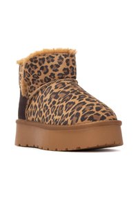 Botas de tobillo con estampado de leopardo y borde de piel de topo, material de ante suave y una suela gruesa y texturizada color tostado. Diseño redondeado para mayor comodidad.