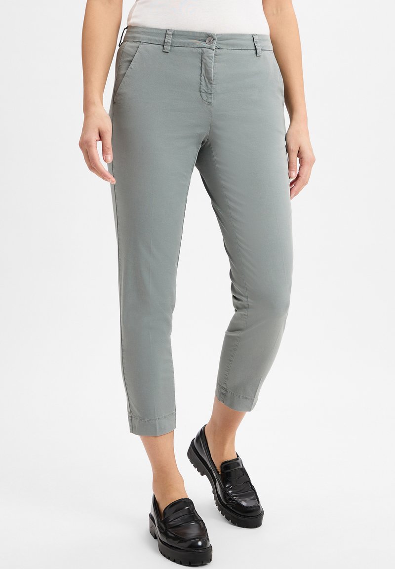Helle graue Chinos mit slim Fit, featuring einen Knopfverschluss und Seitentaschen. Der Stoff hat eine glatte Textur und ein knöchellanges Design.