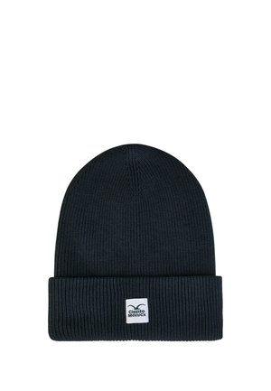 Schwarze gerippte Strickmütze mit umgeklapptem Rand und kleinem weißem rechteckigem Etikett mit dem Cleptomanicx-Markenlogo.