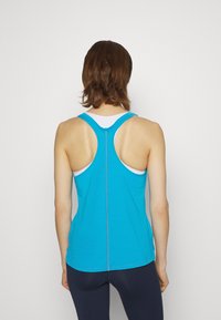 Top de tirantes sin mangas de color azul con diseño de espalda nadadora, fabricado en tejido ligero. Presenta una costura en contraste a lo largo de la costura trasera.