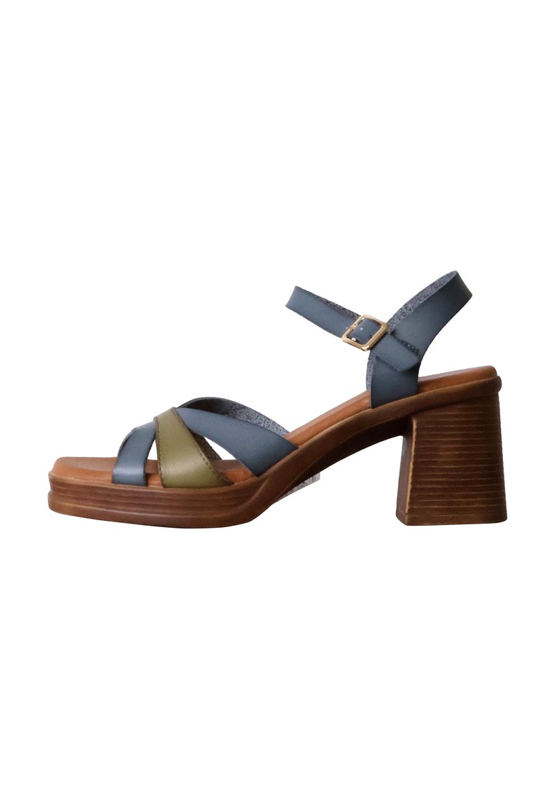 Plattformsandalen mit einem Holzabsatz. Beinhaltet blaue und olivgrüne Riemen. Verstellbarer Knöchelriemen mit einer metallischen Schnalle. Glatte Ledertextur.