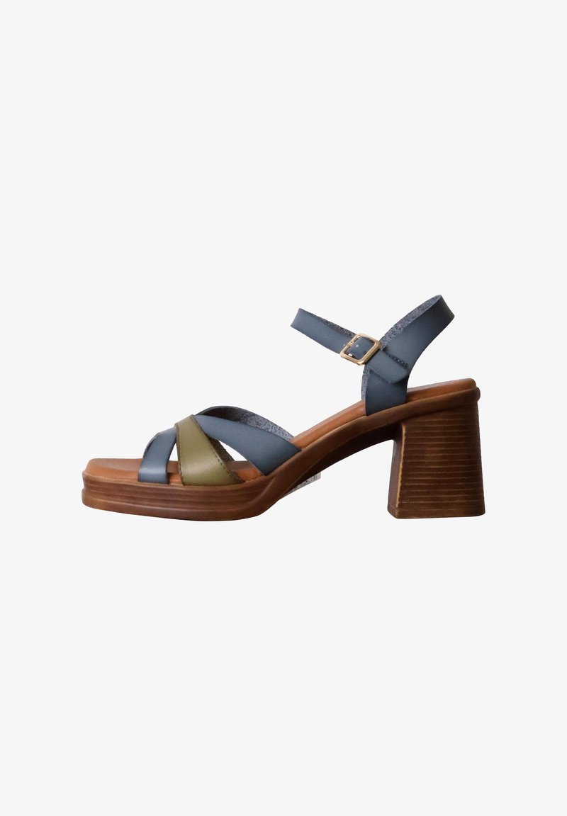 Platform sandals with a wooden heel. Features blue and olive green straps. Adjustable ankle strap with a metallic buckle. Smooth leather texture.