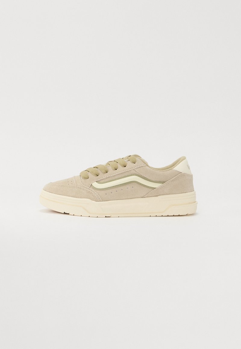 Baskets basses en daim beige avec semelle crème, lacets à l'avant, et un léger motif ondulé sur le côté, vues de l'extérieur.