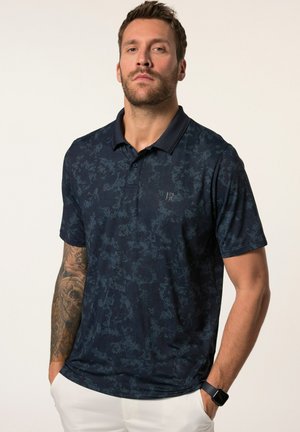 Camisa polo azul marino de tejido ligero, con un sutil patrón abstracto, mangas cortas y cuello tipo polo.