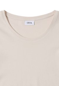 Jasno-beżowa koszulka z krótkim rękawem i okrągłym dekoltem. Wykonana z gładkiego, miękkiego materiału. Posiada metkę z napisem "CECIL" na czarnym tle.