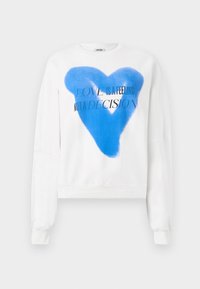 Felpa bianca con una grande grafica a forma di cuore blu e la scritta "L'AMORE È UN SENTIMENTO NON UNA DECISIONE." Tessuto morbido, maniche lunghe, design cropped.