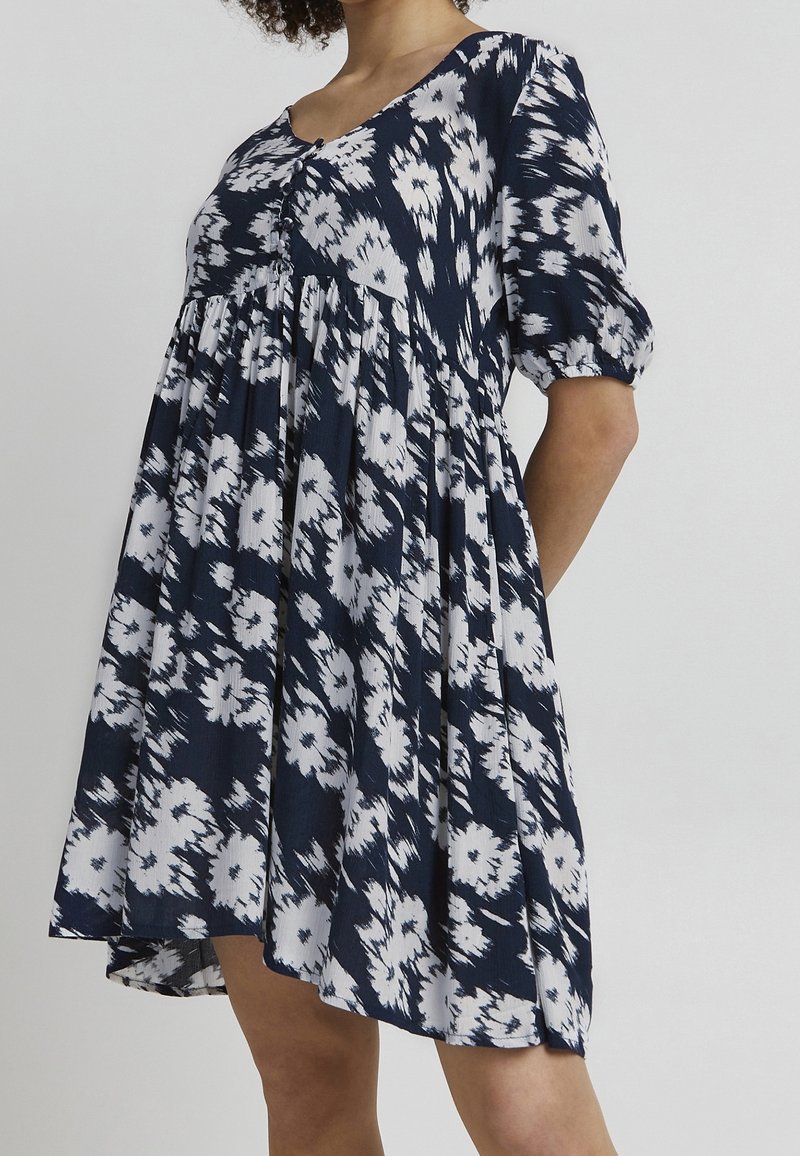 Tmavě modré šaty s květinovým potiskem, krátkými nabíranými rukávy, knoflíkovým zapínáním vpředu a rozšířenou siluetou z lehkého materiálu s texturovaným vzorem.