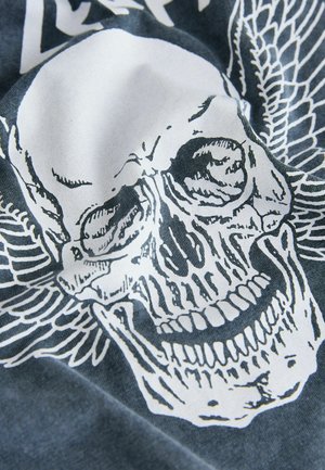 Graafinen t-paita, jossa näkyy suuri valkoinen kallo siivillä tummanharmaalla taustalla; pehmeä kangas, jossa sileä pinta.