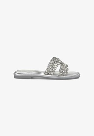 Zilveren schuifsandalen met een platte zool, twee brede banden en strassversieringen voor extra textuur en detail.