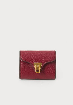 Red leather wallet with a textured finish, featuring a golden metal clasp and curved flap design. Compact rectangular shape.