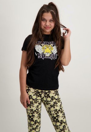 Zwarte T-shirt met een tijger en vleugels grafiek, gecombineerd met zwarte legging met een gele bloemenpatroon. Casual ontwerp en pasvorm.