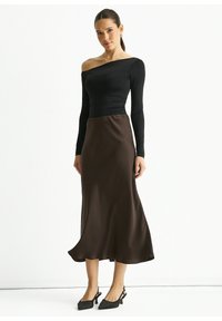 Black long-sleeve off-shoulder top paired with a flowing brown satin midi skirt, featuring a smooth texture and a subtle silhouette.