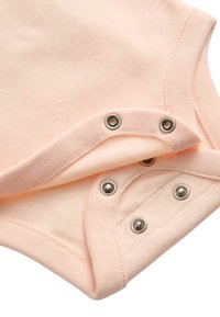 Bavlněné body broskvové barvy s měkkou látkou, kulatým výstřihem a niklovými patentkami na spodní části pro snadnou výměnu.