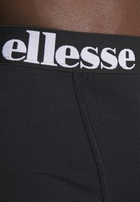 Svarta boxerkalsonger med en vit elastisk midjeband som har "ellesse"-logotypen. Materialet är mjukt med en figurnära design.