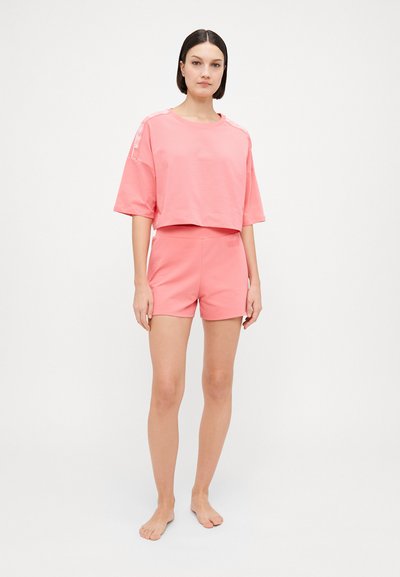 Pink cotton cropped t-shirt with short sleeves, paired with matching pink shorts. Simple design without patterns or accents.