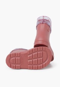 Stivali da pioggia rosa in gomma con un bordino trasparente e decorato, suole testurizzate e un discreto marchio sul lato. Progettati per resistere all'acqua.