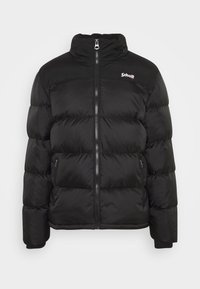 Schwarze Pufferjacke mit hohem Kragen, Frontreißverschluss und Seitentaschen. Verfügt über ein gestepptes Design und ein Logo auf der oberen linken Brust.