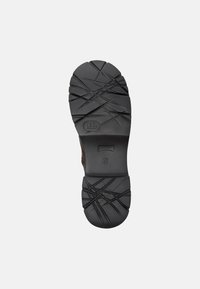 Suola di scarpa in gomma nera con modelli di battistrada testurizzati, che mostrano scanalature e creste per la trazione. Presenta un logo e la marcatura della taglia.