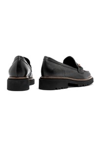 Czarne skórzane mokasyny z teksturowanym wykończeniem, skośnym kształtem, okrągłym noskiem oraz grubymi gumowymi podeszwami z bieżnikiem. Obecny dekoracyjny akcent.