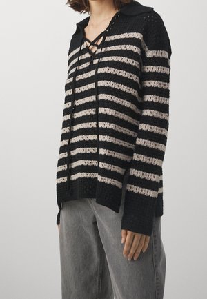 Maglione a righe nero e avorio, lavorato a maglia, con colletto e allacciatura sul davanti, dalla vestibilità ampia. Il tessuto presenta un motivo strutturato e polsini a coste.