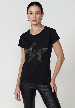Camiseta de algodón negra con un diseño de estrella metálica texturizada. Mangas cortas, escote redondo y un sutil logo en el dobladillo.
