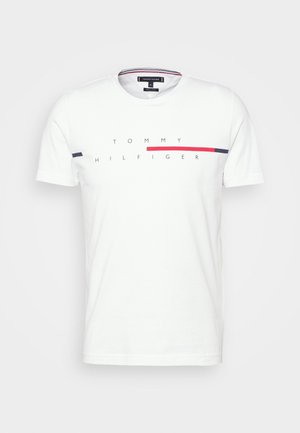 T-shirt blanc à manches courtes et col rond avec le texte "TOMMY HILFIGER" et des rayures horizontales rouges et bleu marine sur la poitrine.