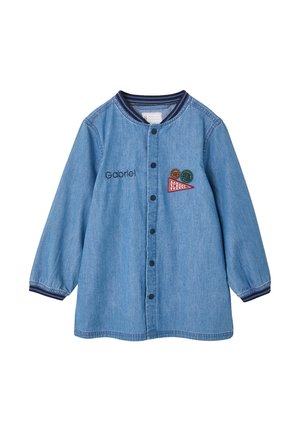 Blue denim long-sleeve jacket with snap buttons, striped collar and cuffs, name "Gabriel" embroidered, and three colorful school-themed patches.