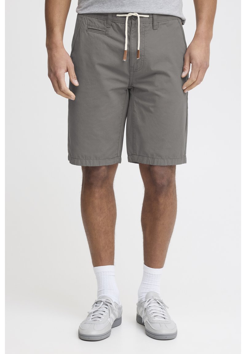 Shorts en coton gris avec une taille à cordon de serrage, des poches latérales et une coupe décontractée. Présente une texture lisse et un ourlet net.