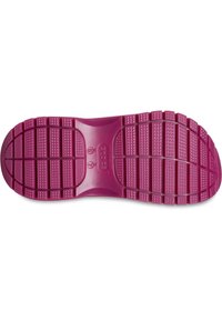 Suela de zapato de goma de color rosa brillante que presenta un patrón de banda de rodadura texturizado con agarres cuadrados y circulares para una mejor tracción.